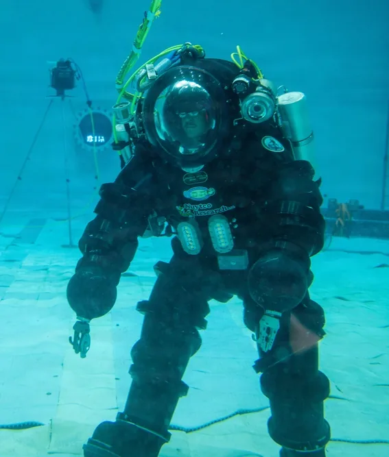Navy diver walking the floor of a test pool in an atmospheric diving suit