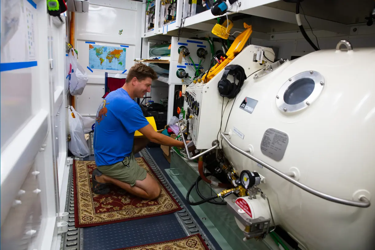 Supervisor working beside a deck decompression chamber aboard a NOAA vessel