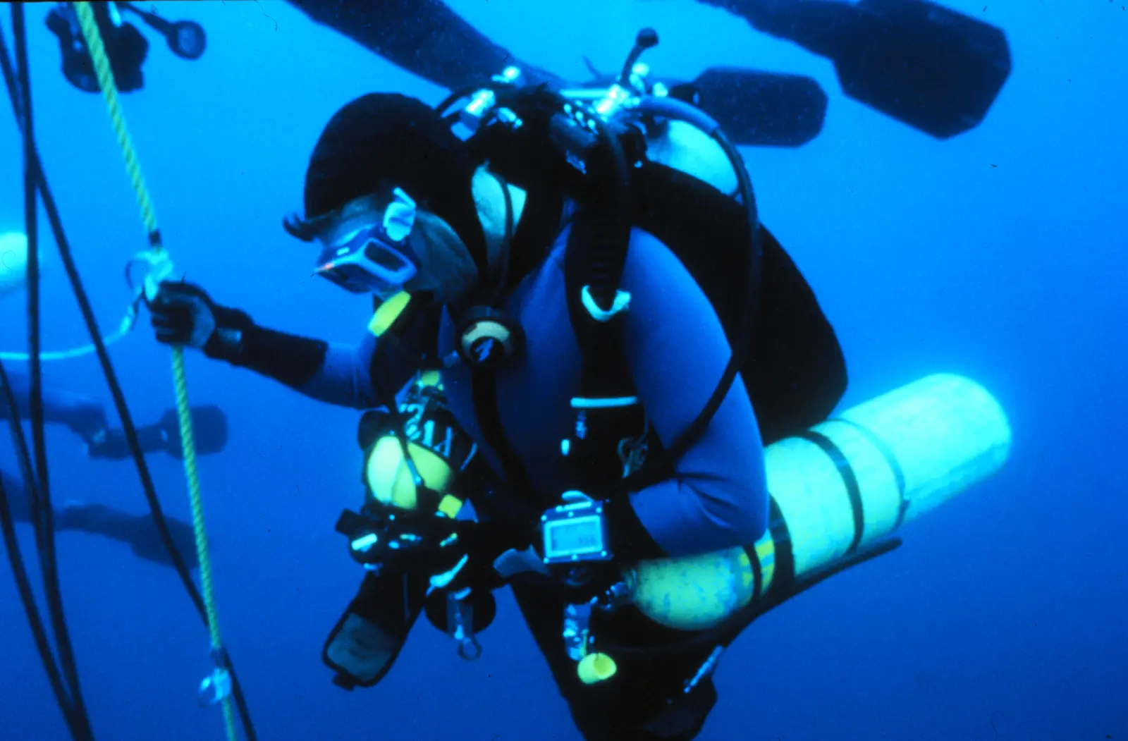 Technical diver carrying multiple cylinders during an underwater decompression stop